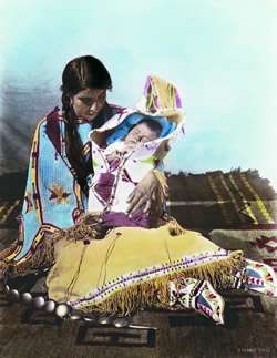 The mother holding the child was Blanch Roubideaux, daughter of Louis Roubideaux, a French/Lakota interpreter for the Rosebud Sioux Reservation. 16 X 20 Color print originally hand tinted by Julia

courtesy of The Pioneer Photography of Julia E. Tuell, 